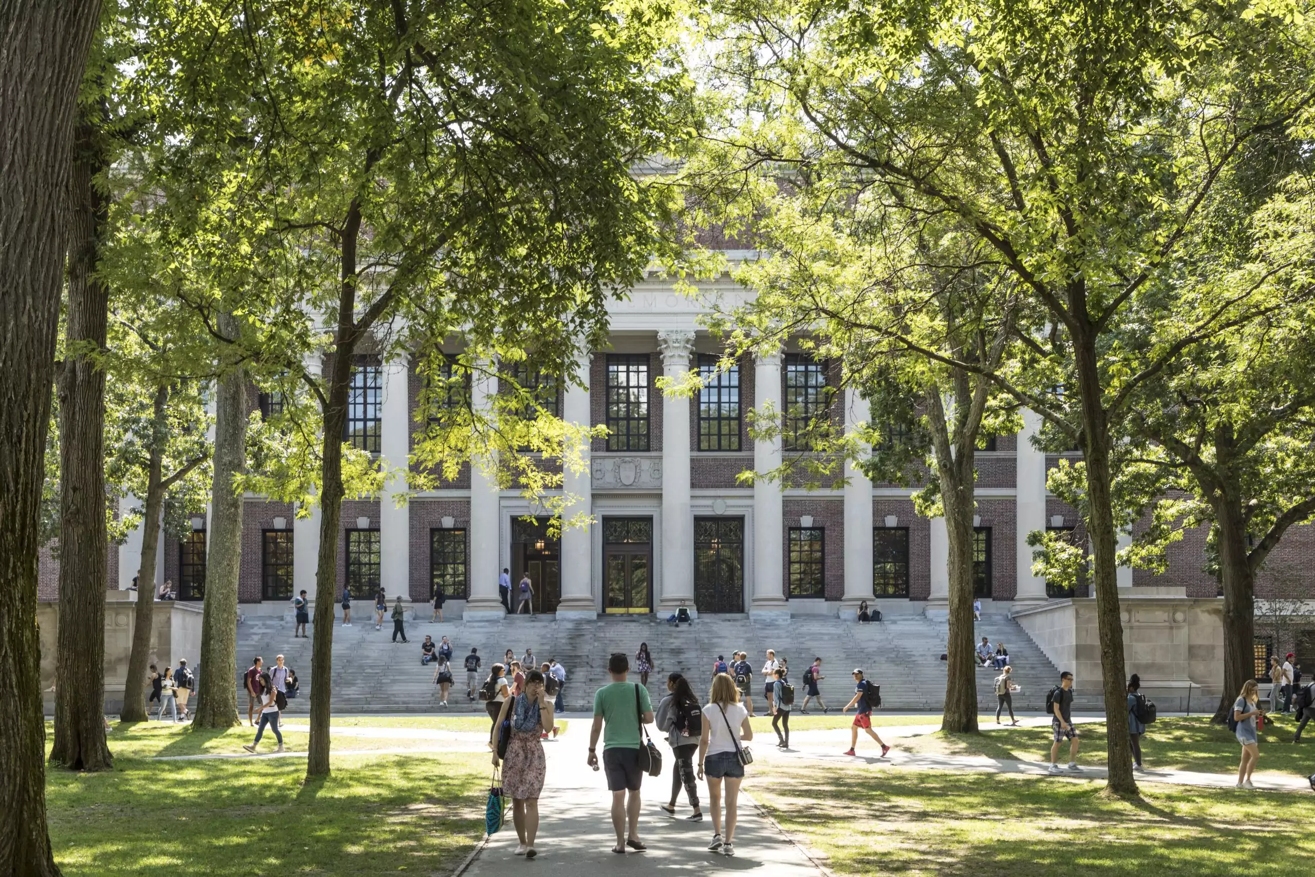 Students and tourists rest in lawn chairs in Harvard Yard, the open old heart of Harvard University campus