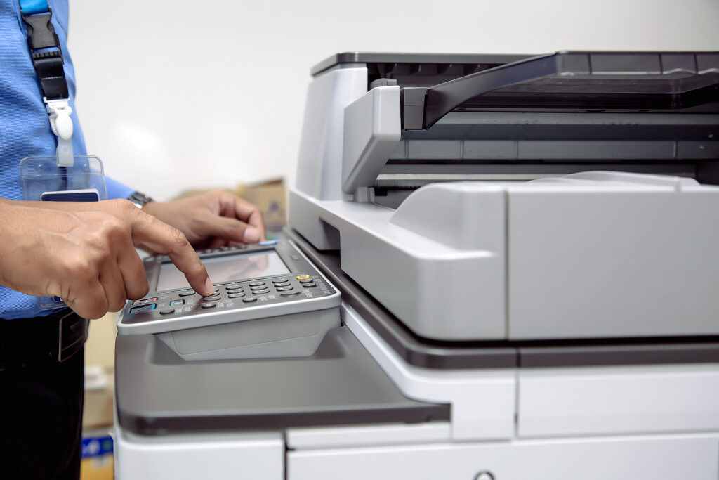 Business professional uses scanner to scan documents.